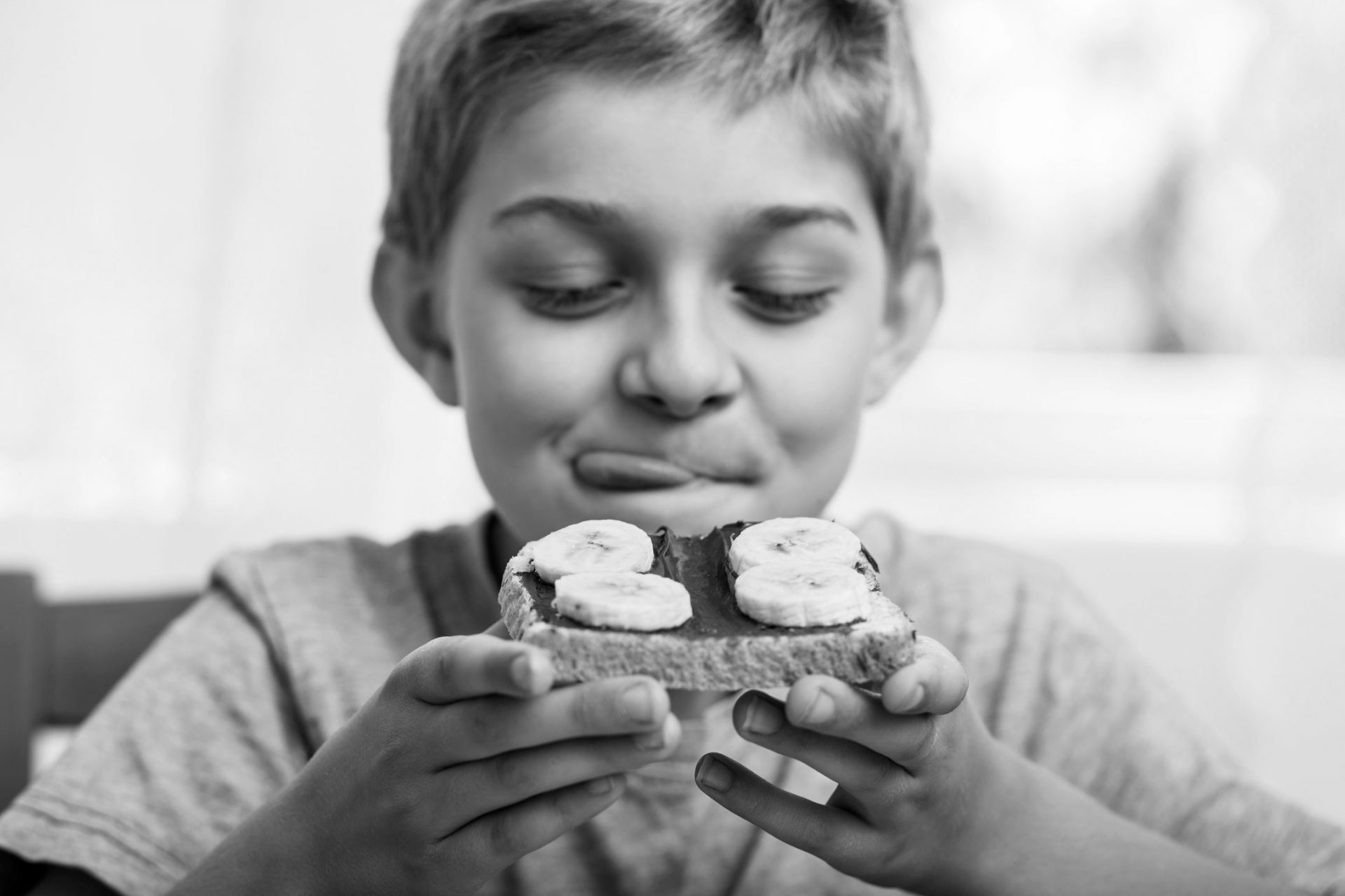 gutt spiser brødskive med nugatti og banan